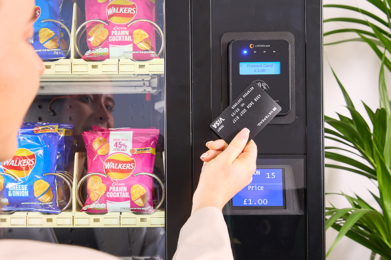 A woman uses a credit card to pay at a P66 card reader.