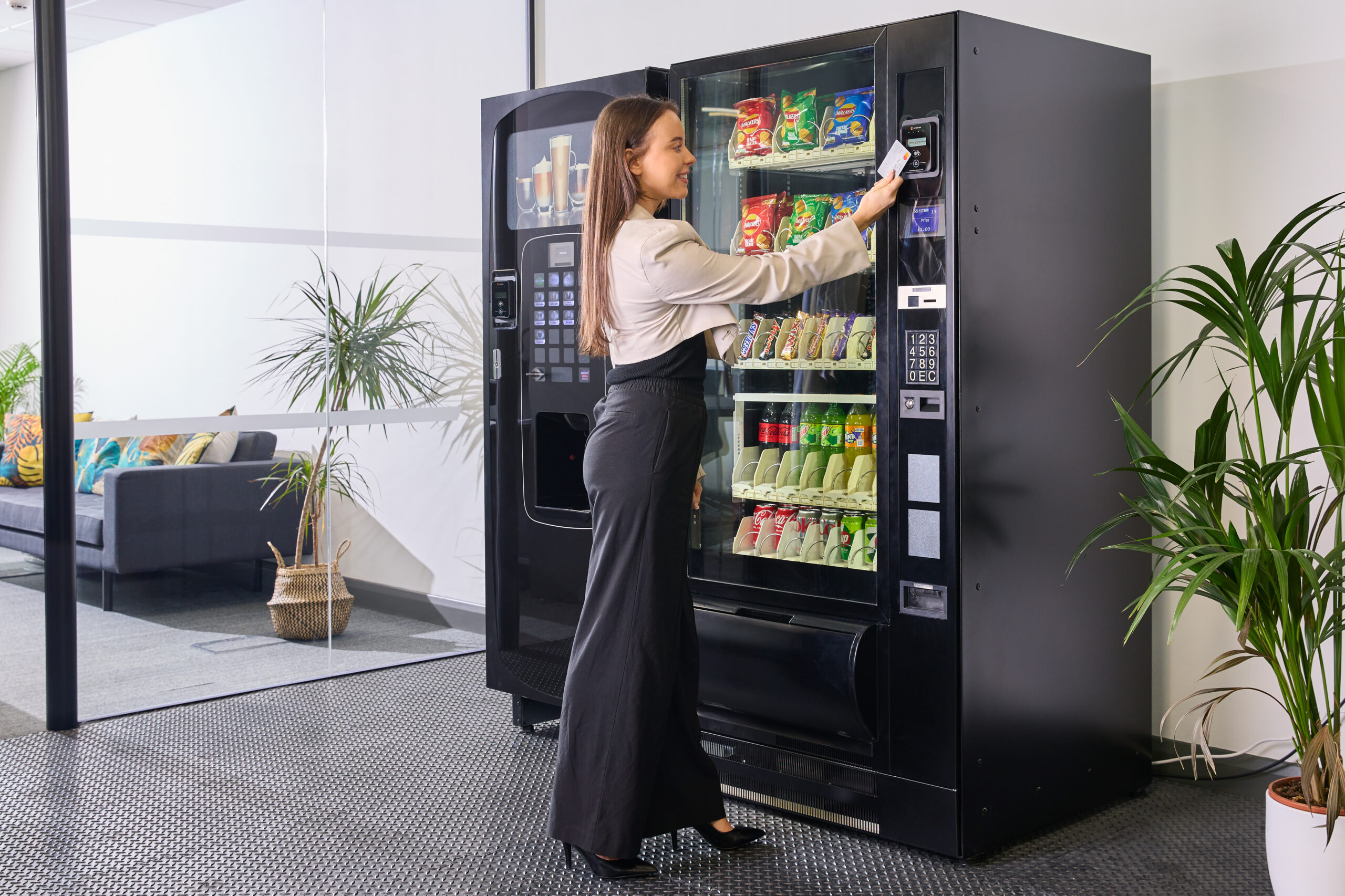 A woman taps to pay at a vending machine.